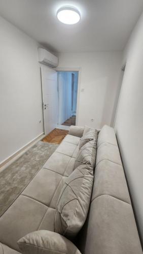 a living room with a large couch in a room at City Center Relax Podgorica in Podgorica