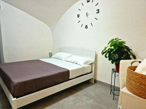 a bedroom with a bed and a clock on the wall at Camera con Vista in Naples