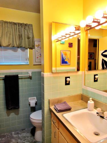 a bathroom with a sink and a toilet and a mirror at Eric and Nancy's Boutique Bed and Breakfast in Tampa