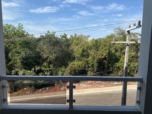 a window with a view of a street and trees at Flat 213 Ilha Bela Alter do Chão in Alter do Chao