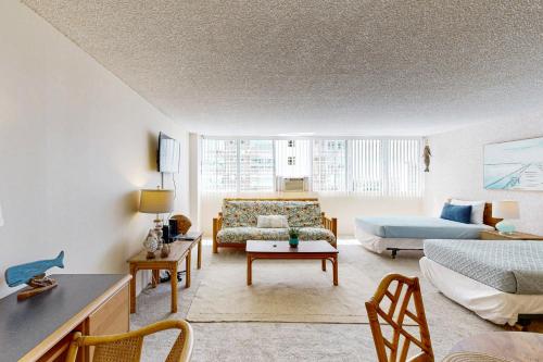 a living room with a bed and a couch at Tradewinds Plaza 906 in Honolulu