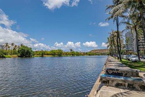 a view of a lake with palm trees and buildings at Tradewinds Plaza 906 in Honolulu