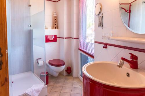 a bathroom with a red sink and a toilet at Ginster in Zingst