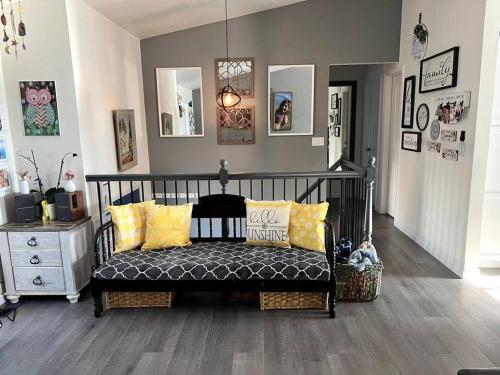 a room with a bench with yellow pillows on it at Hot Tub Steam Shower Gym in Charming Family Home! in Lafayette