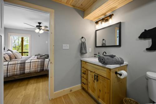 a bathroom with a sink and a bed at Lazy Bear in Sevierville