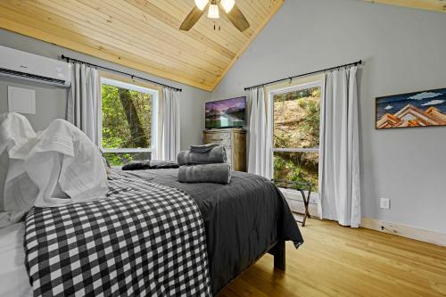 a bedroom with a bed and two windows at Lazy Bear in Sevierville