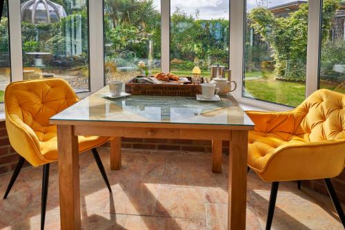 a dining room with a table and two chairs at Saltmarsh Rooms at Armeria in Wells next the Sea in Wells next the Sea