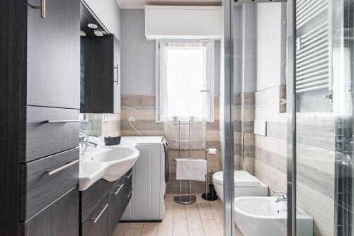 a bathroom with two sinks and a toilet and a window at Stile e Comfort in Città con Wi-Fi in Carpi