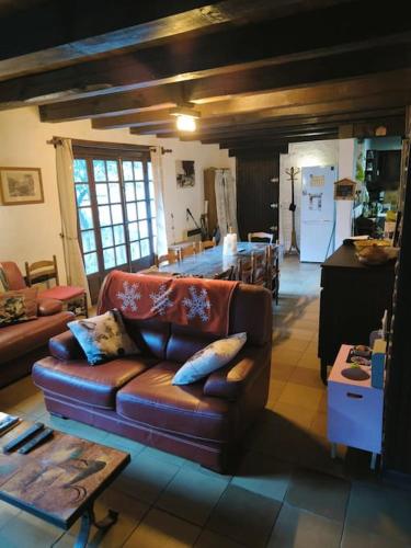 un salon avec un canapé en cuir et une cuisine dans l'établissement Grand et Charmant chalet, à Saint-Martin-Vésubie