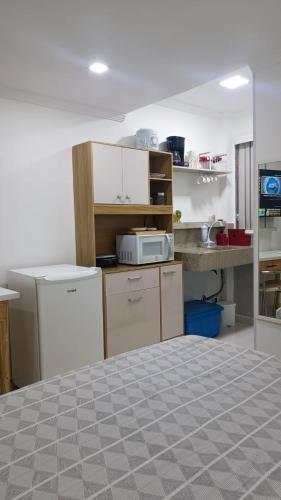 a room with a kitchen with a bed in it at ** SUITE PRIVATIVA PRAIA DO FORTE CABO FRIO ** in Cabo Frio