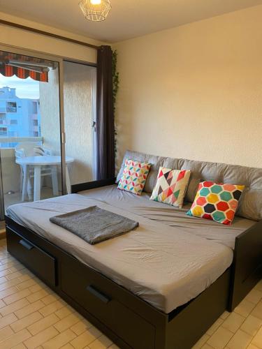 Cette chambre comprend un grand lit et un canapé. dans l'établissement charmant studio dans résidence en bord de mer, au Grau-du-Roi