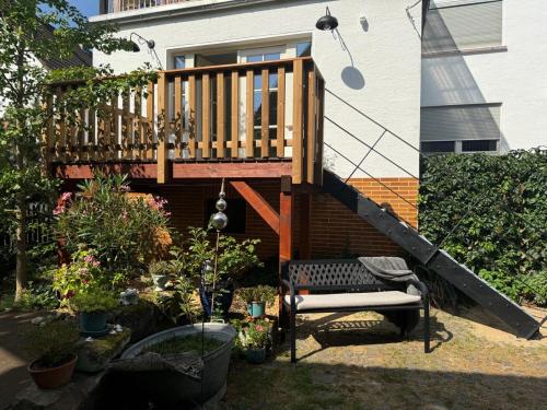 a wooden deck with a bench in a yard at Großes neues Appartement Mein Burgwaldtraum in Rauschenberg