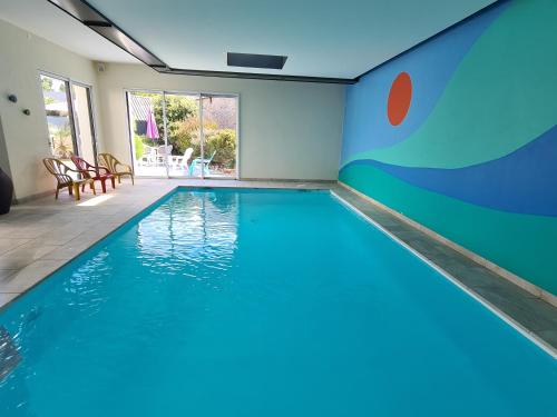 - une piscine dans une maison ornée d'une grande peinture murale dans l'établissement Villa Ty Mam Goz, 50m mer, piscine intérieure, SPA, 11 personnes, à Santec