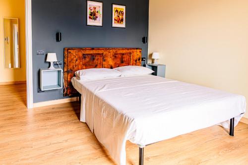 a bedroom with a large bed with a wooden headboard at Casale Bellavista 1853, Cremia, Lago di Como in Cremia