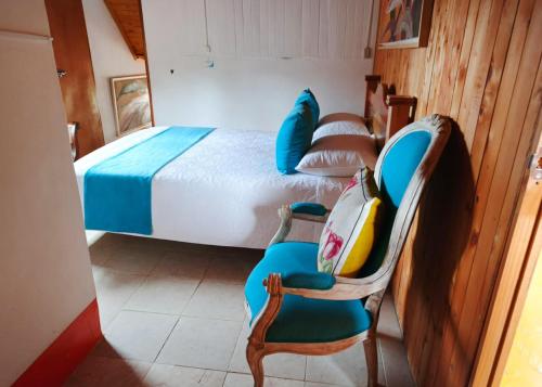 a bedroom with a bed and chairs in a room at Memorias del Palmar in Jericó