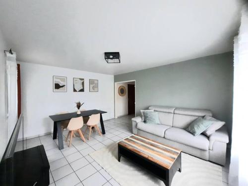 un salon avec un canapé et une table dans l'établissement Joli appartement Proche Orléans, à Saint-Jean-le-Blanc