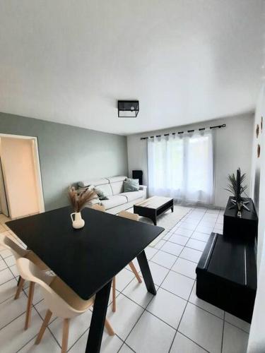 un salon avec une table et un canapé dans l'établissement Joli appartement Proche Orléans, à Saint-Jean-le-Blanc