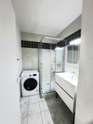 une salle de bain avec douche et machine à laver dans l'établissement Joli appartement Proche Orléans, à Saint-Jean-le-Blanc