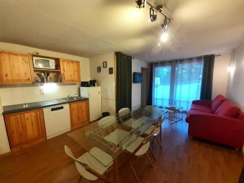 - un salon avec une table en verre et un canapé rouge dans l'établissement Chalet Florence - 3 Pièces pour 8 Personnes MAE-6511, à Modane