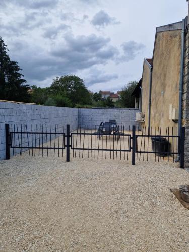 a fence with a car parked behind a brick wall at La Forge in Parmilieu