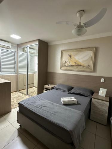 a bedroom with a bed and a painting on the wall at apartamento climatizado, 3 quartos c suíte garden in Cuiabá