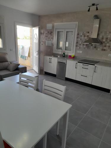 a kitchen with white cabinets and a table and chairs at La Vega in Tarifa