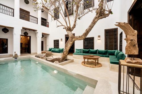 マラケシュにあるRIAD Ylha MARRAKECHのプールと木のあるリビングルーム