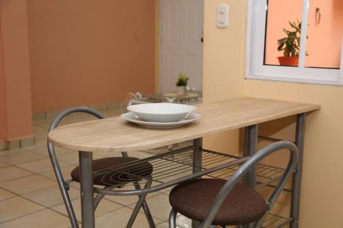 a table and chairs with a bowl on top of it at Mango House in Florencia