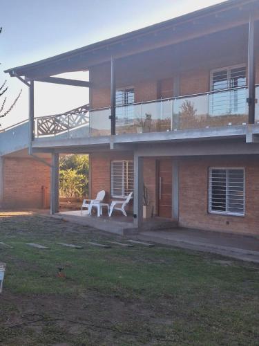 a house with a balcony and two chairs on a patio at Apart de Sierras in Nono