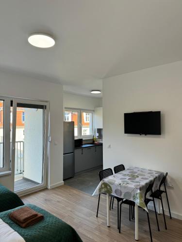a kitchen and living room with a table and chairs at Abra Apartment X in Poznań