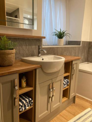 a bathroom with a sink and a mirror at Wynnstay Apartment, Harbour and Mountain Views in Barmouth