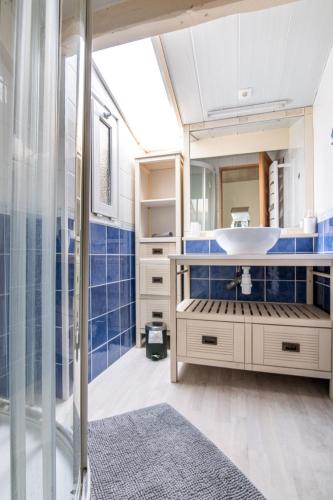La salle de bains est pourvue d'un lavabo et de carrelage bleu. dans l'établissement LE NID - HYPER CENTRE CHOLET - 25 MIN PUY DU FOU, à Cholet