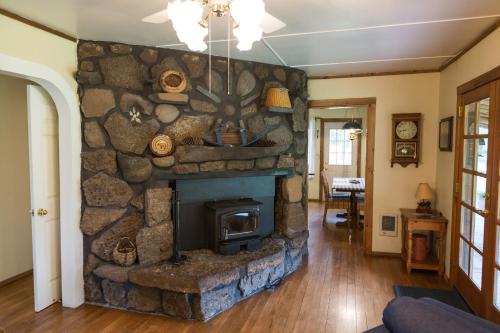 a stone fireplace in a living room with a stone wall at Lonesome Duck Ranch in Chiloquin