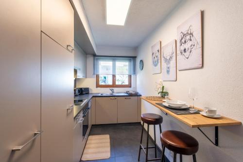 a kitchen with a counter and a table with stools at No 8 Bed & Bar in Verbier