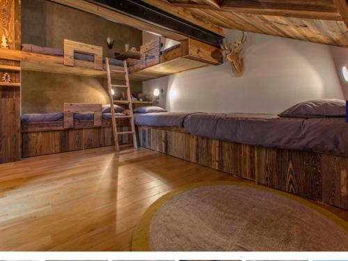 une chambre avec deux lits superposés et un tapis dans l'établissement Très bel appartement Duplex 9 couchages, à Megève