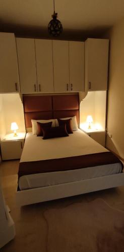 a bedroom with a large bed with two lamps at Les dunes in Sousse
