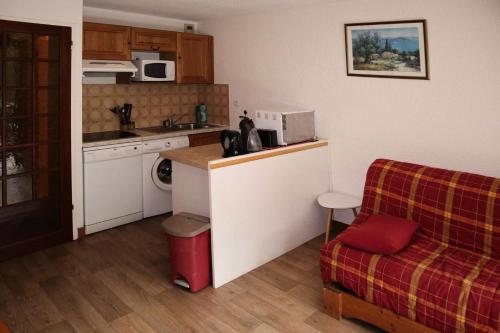 - une cuisine avec un comptoir et un canapé dans la chambre dans l'établissement Résidence Les Flocons - Résidence Les Flocons MAE-6164, aux Orres