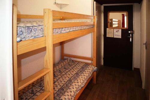 - deux lits superposés dans une chambre avec une porte dans l'établissement Résidence Les Flocons - Résidence Les Flocons MAE-6164, aux Orres