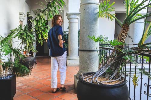 a woman standing in a room with plants at Hotel Boutique Naura Centro in Oaxaca City