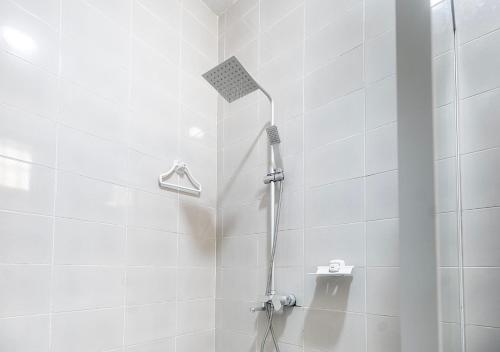 El baño incluye ducha blanca con cabezal de ducha. en magnifique appartement, de deux balcons, très spacieux, en Baguida