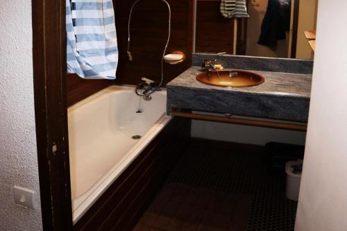 une salle de bain avec un lavabo et une baignoire et un lavabo dans l'établissement Résidence Le Pouzenc - Studio calme pieds de pistes MAE-6471, aux Orres