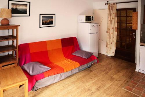 Cette chambre comprend un lit coloré et un réfrigérateur. dans l'établissement Résidence Les Flocons - Grand studio cabine 6 personnes MAE-6541, aux Orres