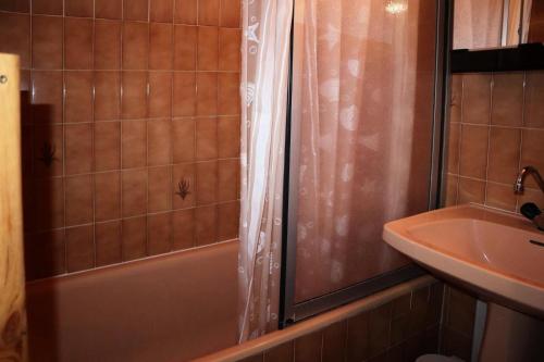 La salle de bains est pourvue d'un rideau de douche à côté d'un lavabo. dans l'établissement Résidence Les Flocons - Grand studio cabine 6 personnes MAE-6541, aux Orres