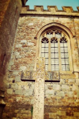 a cross on the side of a building with a window at B&B Dorwyn Manor in Avebury