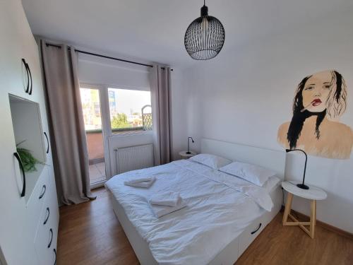a bedroom with a bed with a painting on the wall at Iulius Town Charm Cozy Apartments in Timişoara