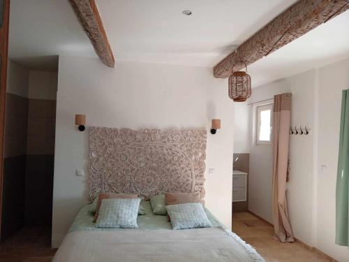 - une chambre avec un lit avec une tête de lit dans l'établissement Gîte Plaissan- Chez Laure&Marc, à Plaissan