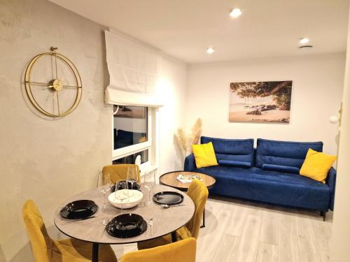 ヘルにあるWhite Shell Apartament Helの青いソファとテーブルのあるリビングルーム