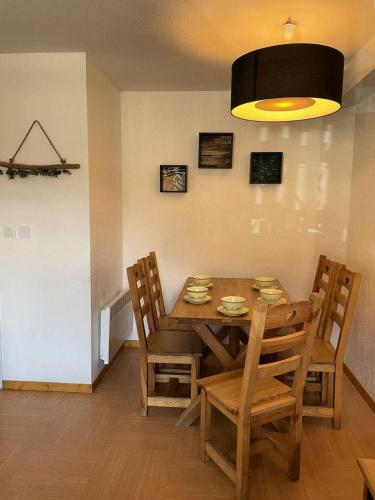 une salle à manger avec une table et des chaises en bois dans l'établissement Résidence Parc Des Airelles - APPARTEMENT PARC DES AIRELLES 110 MAE-7291, aux Orres