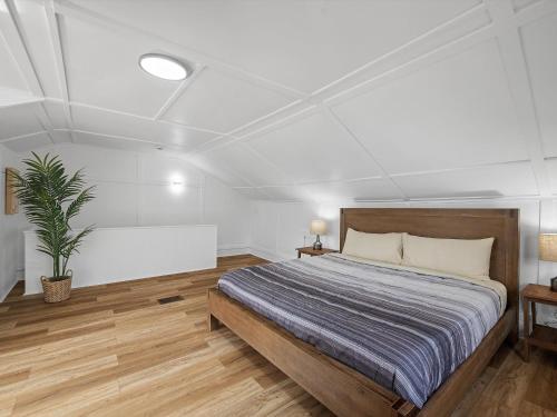 Un dormitorio con una cama y una planta en maceta. en Bloomfield, Shadyside !D Spacious and Unique Bright Private Bedroom with Shared Bathroom, en Pittsburgh