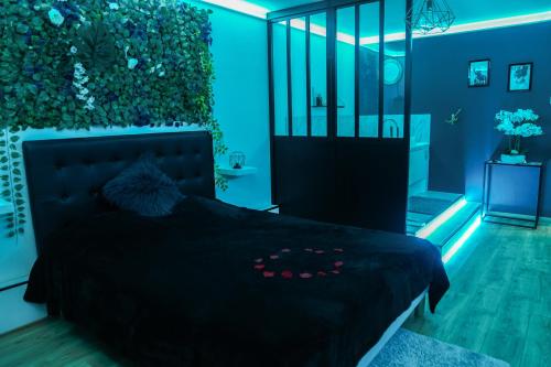 a bedroom with a black bed with a plant on the wall at L'Atelier de rêves in Metz